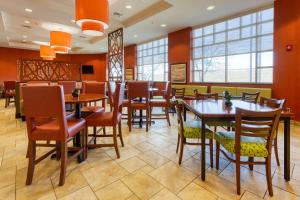 印第安纳波利斯印第安纳波利斯东北德鲁套房酒店的餐厅设有木桌、椅子和窗户。