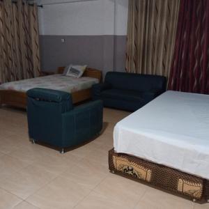SpintexPemicsa Hotel Accra的酒店客房 - 带一张床、一张床和椅子