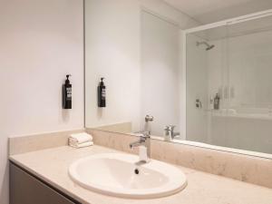 悉尼ibis Styles Sydney Central的白色的浴室设有水槽和淋浴。