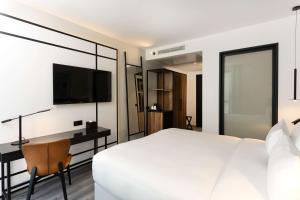 突尼斯Radisson Hotel Tunis, City Center的一间卧室配有一张床、一张书桌和一台电视。