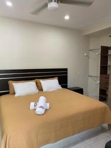 萨尤利塔Hotel y Suites Los Encantos的一间卧室配有一张大床和毛巾