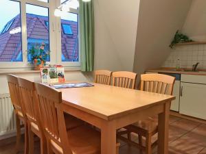 布雷格Hafenhäuser Breege - Ferienwohnung 18 - Ankerplatz的厨房配有木桌和椅子