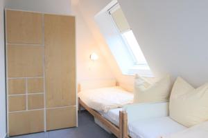 布雷格Hafenhäuser Breege - Ferienwohnung 9 Strandläufer的小型阁楼卧室设有1张床和1扇窗户。