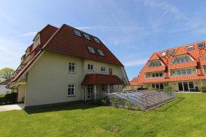 布雷格Hafenhäuser Breege - Ferienwohnung 9 Strandläufer的一座大型白色房屋,设有红色屋顶