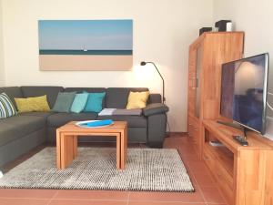朱列斯拉赫Kurparkcarree - Ferienwohnung "Amber"的带沙发、电视和桌子的客厅