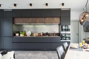 宁多夫_ERL41_ PIER 41的厨房配有黑色橱柜和餐桌