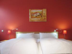 奥斯赛拜-屈隆斯博恩Ferienwohnung Ostseeblick的卧室设有两张床铺和红色的墙壁