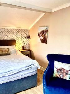 斯基普顿海菲尔德宾馆的一间卧室配有一张床和一张蓝色椅子
