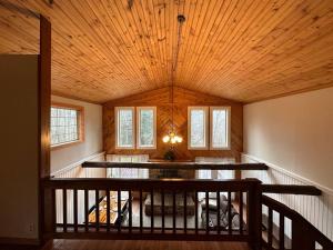 Guys MillsModern Getaway cabin, sleeps 7 Near Meadville的一间带木制天花板和楼梯的客厅