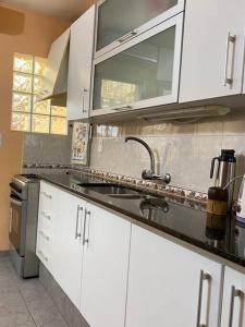 梅塞德斯Casa de dos plantas的厨房配有白色橱柜和水槽