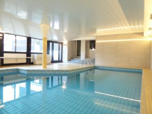 温特贝格Nature Vibes Winterberg Ferienwohnung Pool Sauna Terrasse near Lift的大楼内一个蓝色瓷砖的大型游泳池