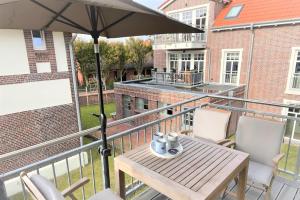 万根沃格Ferienwohnung Inselherz的阳台配有桌子和雨伞。