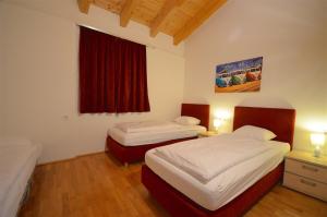 滨湖采尔APT Mountain View by - Alpen Apartments的一间卧室设有两张床和红色窗户。