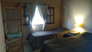 梅赛德斯Angiru的一间小卧室,配有两张床和窗户