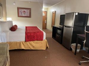科尔尼Kearney Inn and Convention Center的配有床和冰箱的酒店客房