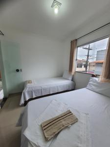 塞古罗港Prédio do Gaguinho的一间设有两张床的房间,上面有毛巾
