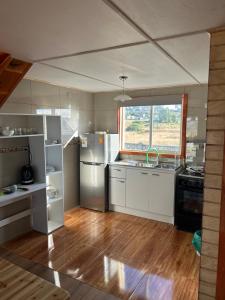 琼奇Cabaña Loft del Sur Premium的一间厨房,配有白色家电和大窗户
