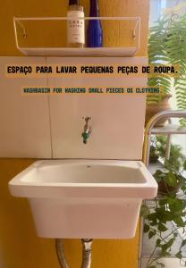 巴西利亚GayFriendly Hostel BSB Airport的浴室内的一个白色水槽,上面有标志