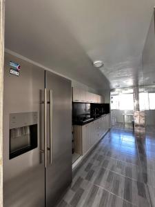 圣玛尔塔Vista increíble Chirama Rodadero的厨房配有不锈钢冰箱和木地板