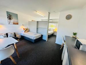 长滩港Beachport Motor Inn的小房间设有床、沙发和桌子