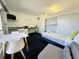 长滩港Beachport Motor Inn的客房设有两张床、一张桌子和一张书桌。