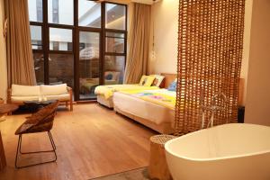 上海上海浦东机场幔麓酒店·宠物友好的带浴缸的浴室以及带一张床和浴缸的卧室。