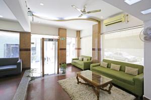 新德里Hotel Ambrosia - A Boutique Hotel的客厅配有绿色沙发和咖啡桌