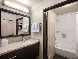 米德瓦尔米德韦尔驻桥套房酒店的一间带水槽和镜子的浴室
