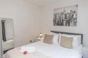 曼彻斯特NovaNest Salford Apartment的卧室配有白色的床和镜子