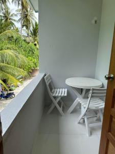福拉杜岛Island Luxury Dive Hotel - Fulhadhoo的阳台的桌子和椅子