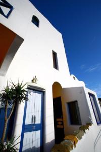 鹅銮鼻垦丁小径民宿的白色的房子,有蓝色的门和棕榈树
