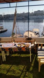 阿斯旺Onaty Narty Guest house的水边的野餐桌和小船