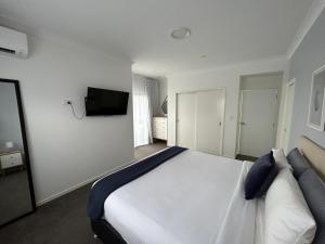 黄金海岸Mermaid - Magic king unit的卧室配有一张床,墙上配有电视。