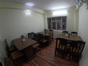 加德满都Hotel Global Village的用餐室配有木桌和椅子