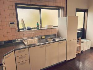 yadori TEN 宿り　甸的厨房配有白色冰箱和水槽