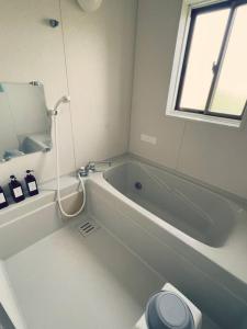 yadori TEN 宿り　甸的白色的浴室设有浴缸和卫生间。