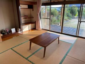 yadori TEN 宿り　甸的客厅设有桌子和大窗户
