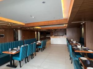 PūrniaHOTEL PRAJYOT的餐厅内带蓝色椅子和桌子的用餐室