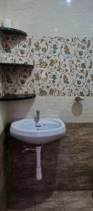 帕罗林Sobitai的浴室设有白色水槽和壁纸