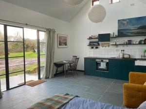 法尔茅斯Tresahor Studio的厨房配有绿色橱柜和桌子