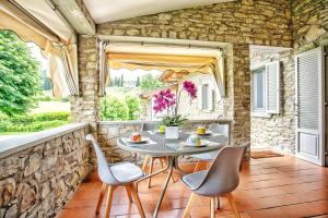 阿雷佐Villa Giuliana的一个带桌椅和石墙的庭院