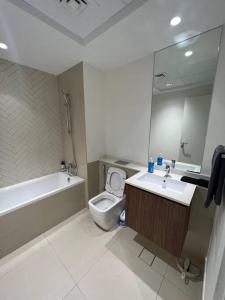 沙迦Cozy beautiful apartment Al zahia mall的带浴缸、卫生间和盥洗盆的浴室