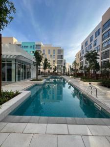 沙迦Cozy beautiful apartment Al zahia mall的大楼前的游泳池