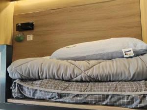 苏州不负韶华青年旅馆的两个枕头坐在一个房间里架子上