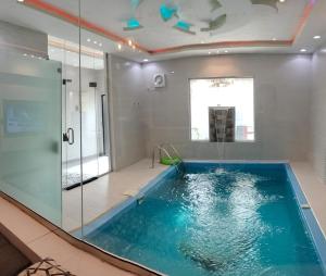 塔伊夫فلل الكناري الراقية的一间带玻璃墙游泳池的浴室