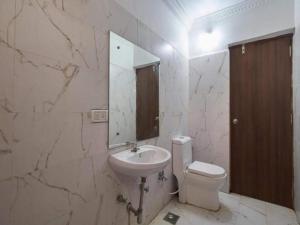 卡兰古特Hotel Shivam Inn - Near Calangute Beach的一间带水槽、卫生间和镜子的浴室
