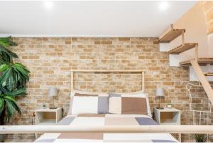 布林迪西Casa Melania的一间卧室设有一张床和砖墙
