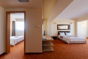 蒂米什瓦拉牛津套房酒店 的酒店客房,设有两张床和镜子