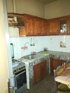 梅克内斯Appartement à Meknès的厨房配有木制橱柜、水槽和炉灶。