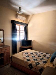 梅克内斯Appartement à Meknès的一间卧室设有一张床和一个窗口